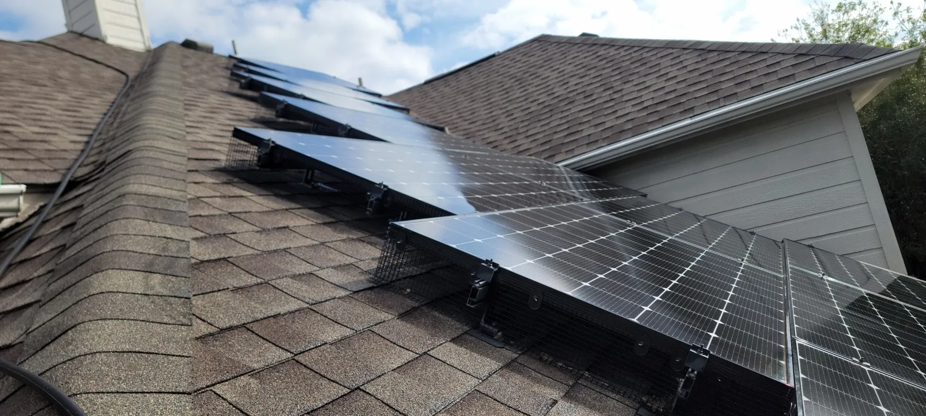 A completed critter guard installation running along the full lower edge of a rooftop solar array